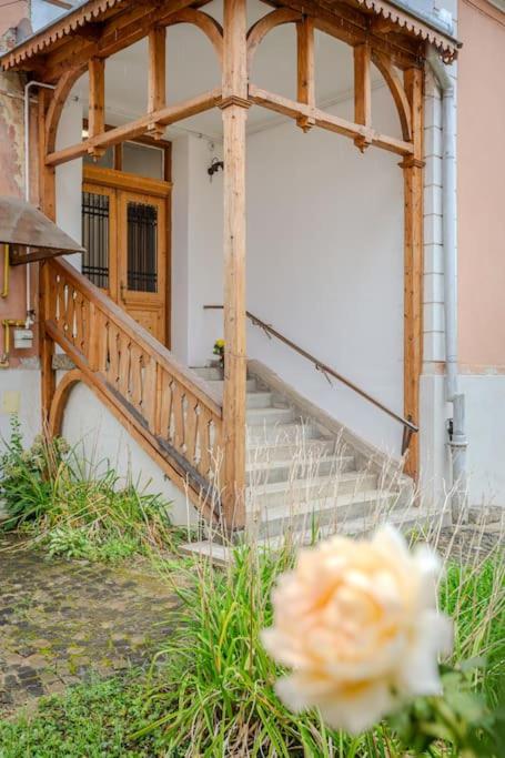 a flower in front of a building with a staircase at GB4 by Rentable in Braşov