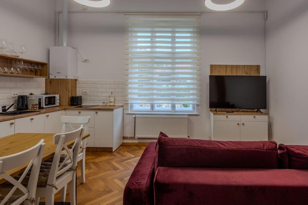 a living room with a red couch and a kitchen at GB4 by Rentable in Braşov