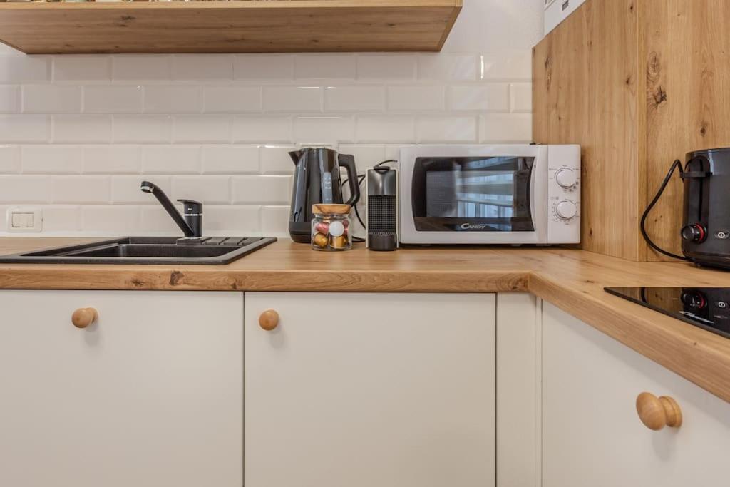 a kitchen counter with a microwave and a sink at GB4 by Rentable in Braşov