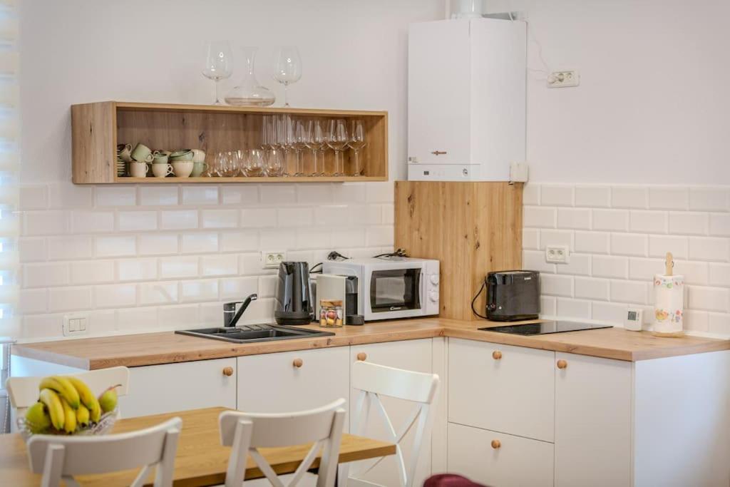 a kitchen with white cabinets and a table with bananas at GB4 by Rentable in Braşov