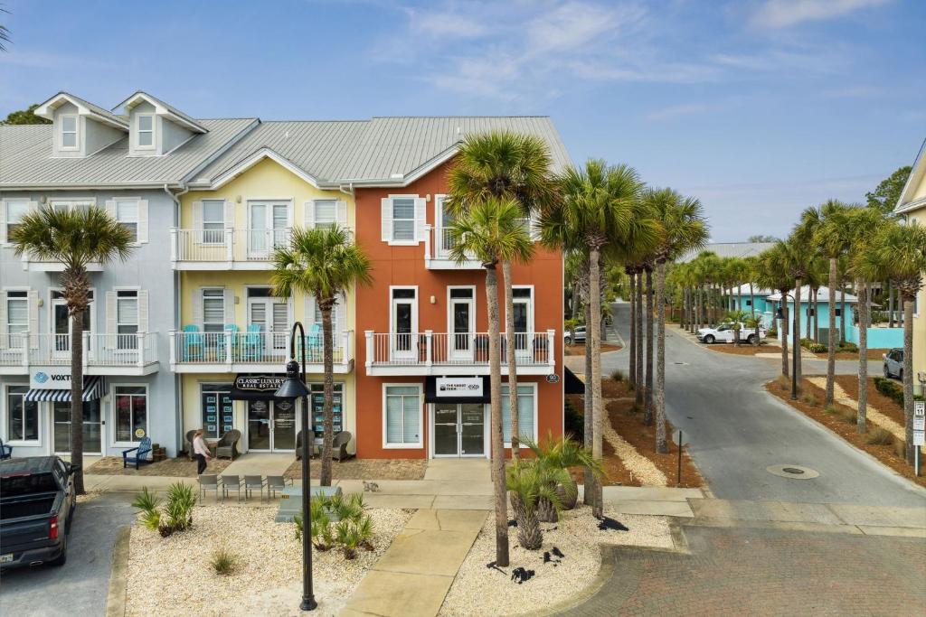 a row of houses on a street with palm trees at Rockaway Beach in Santa Rosa Beach