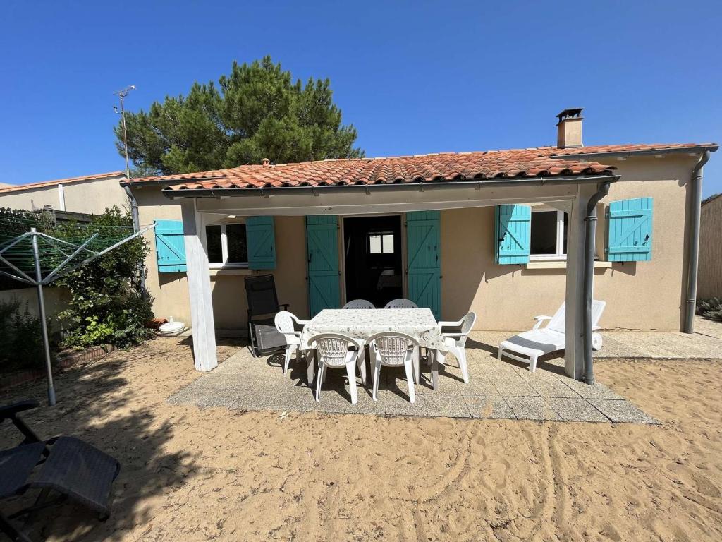 un patio avec une table et des chaises devant une maison dans l'établissement Villa calme avec jardin clos, à 800m de la plage et 600m des commerces à Brétignolles-sur-Mer - FR-1-324-198, à Bretignolles-sur-Mer