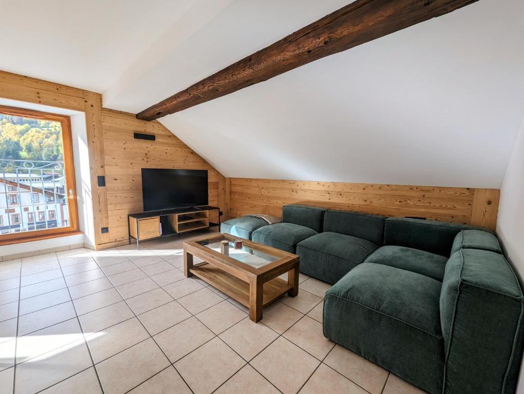 un salon avec un canapé et une télévision dans l'établissement Beau Duplex 100m2 au cœur de Beaufort - avec vue montagnes, à Beaufort