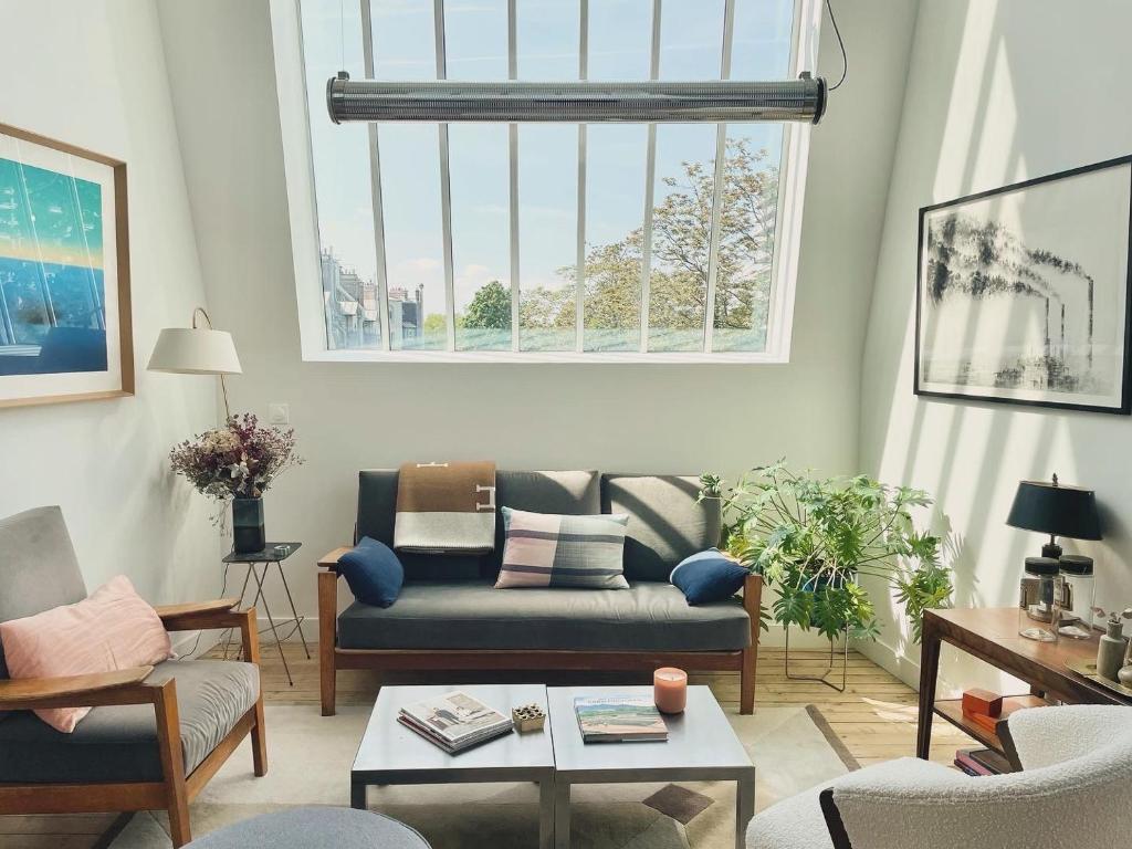 un salon avec un canapé et une table dans l'établissement Atelier d'artiste, vue Tour Eiffel, à Paris