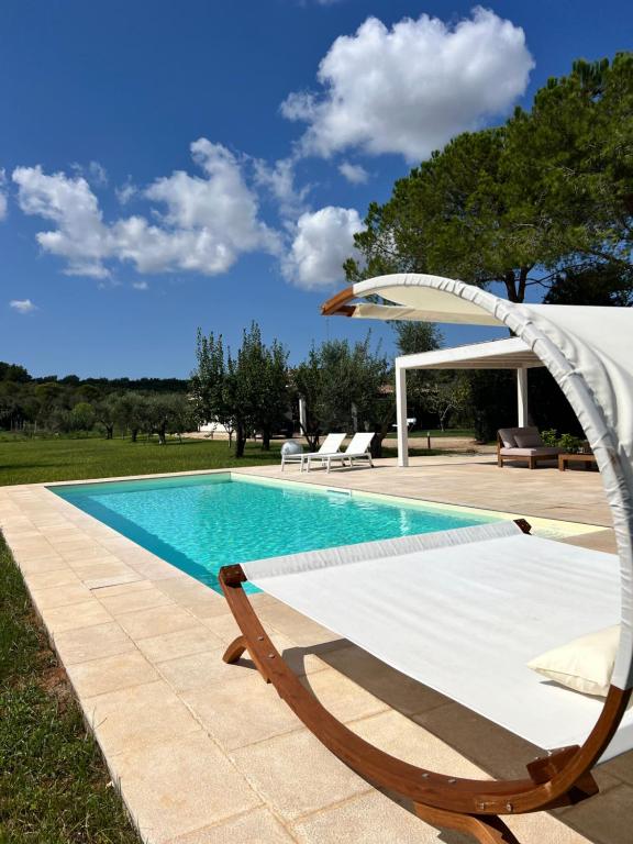 a swimming pool with a chair and an umbrella at Villa Laura in Neviano