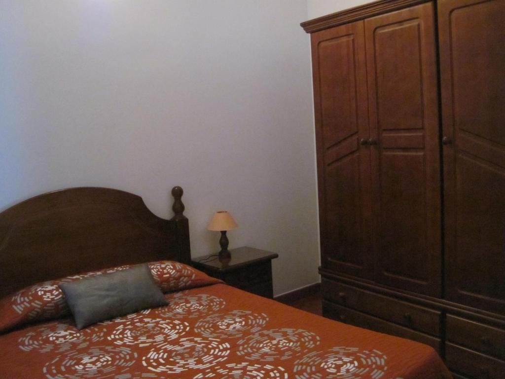 1 dormitorio con 1 cama y un gran armario de madera en Apartamentos Viviendas Vacacionales Pozo de La Salud en Sabinosa