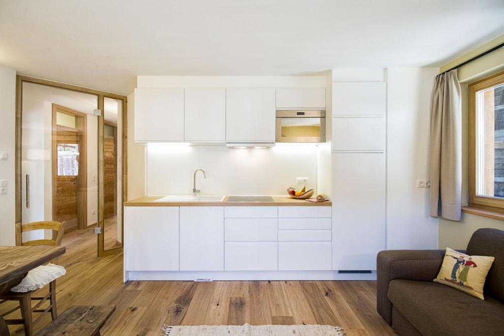 a kitchen with white cabinets and a sink at Chalet Da Mont in Selva di Val Gardena