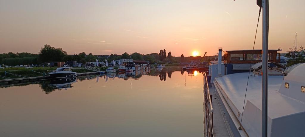 un groupe de bateaux amarrés dans une marina au coucher du soleil dans l'établissement Odyssée gîte sur Péniche, à Saint-Valery-sur-Somme