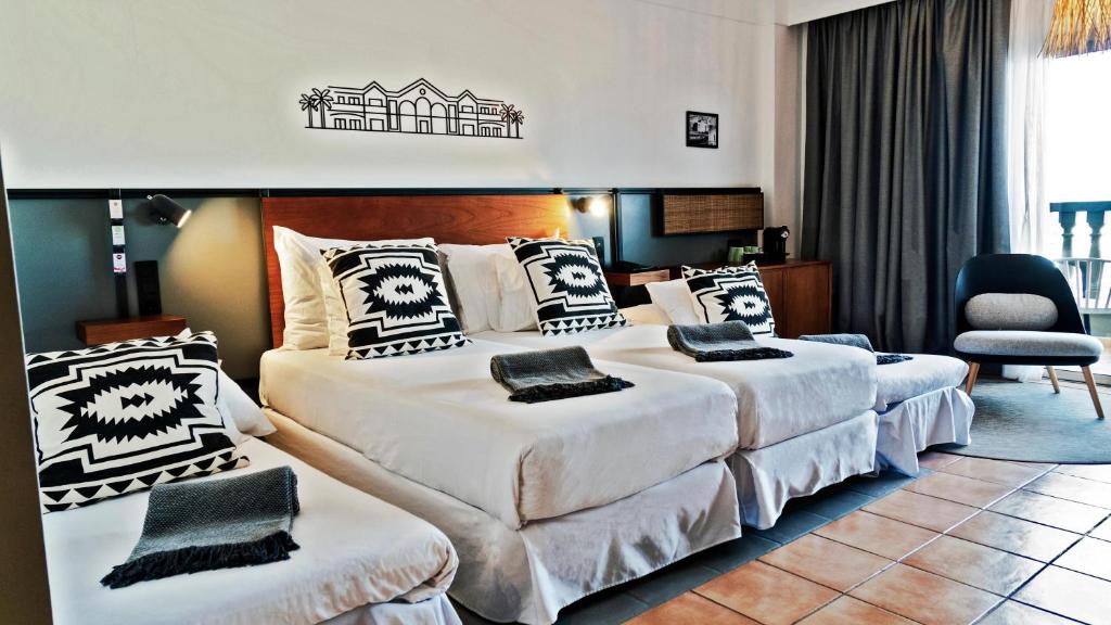a hotel room with two beds and a chair at Coral Cotillo Beach in El Cotillo