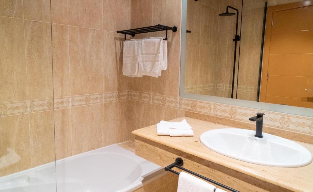 a bathroom with a sink and a mirror at Coral Cotillo Beach in El Cotillo