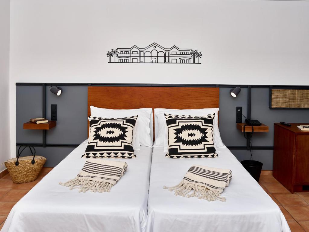 two beds with white sheets and pillows in a room at Coral Cotillo Beach in El Cotillo