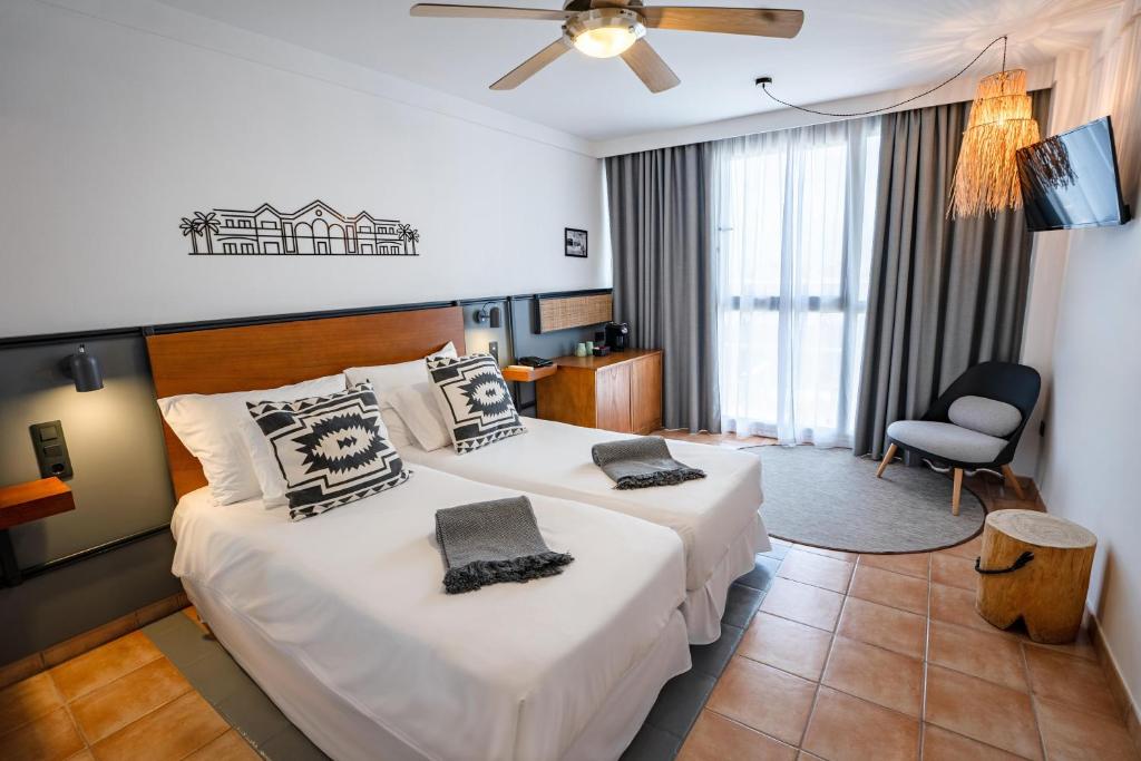 a hotel room with two beds and a chair at Coral Cotillo Beach in El Cotillo
