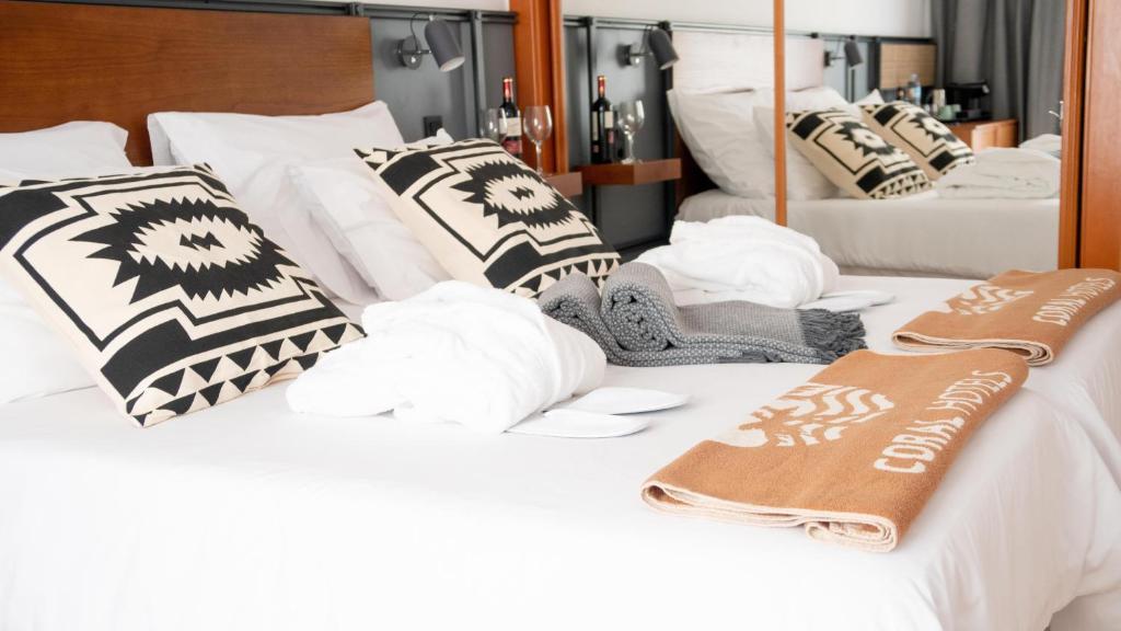 two white beds with pillows and towels on them at Coral Cotillo Beach in El Cotillo