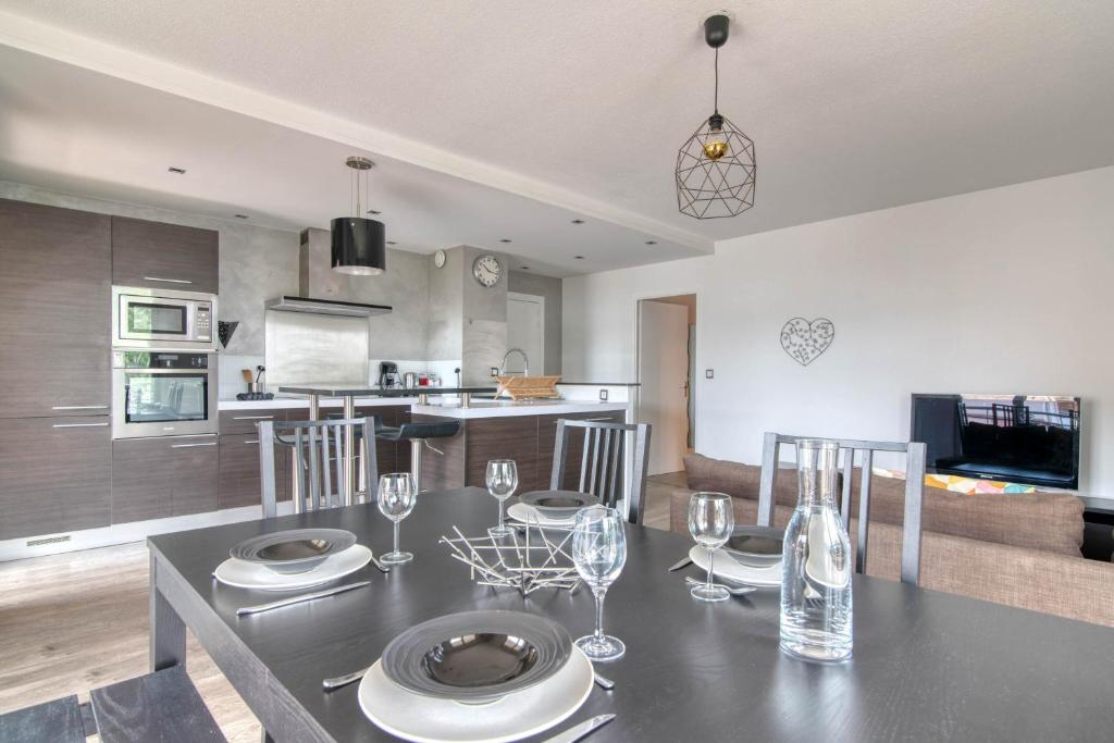 a dining room and kitchen with a table and chairs at L'Arène de coeur - appt avec piscine partagée in Toulouse