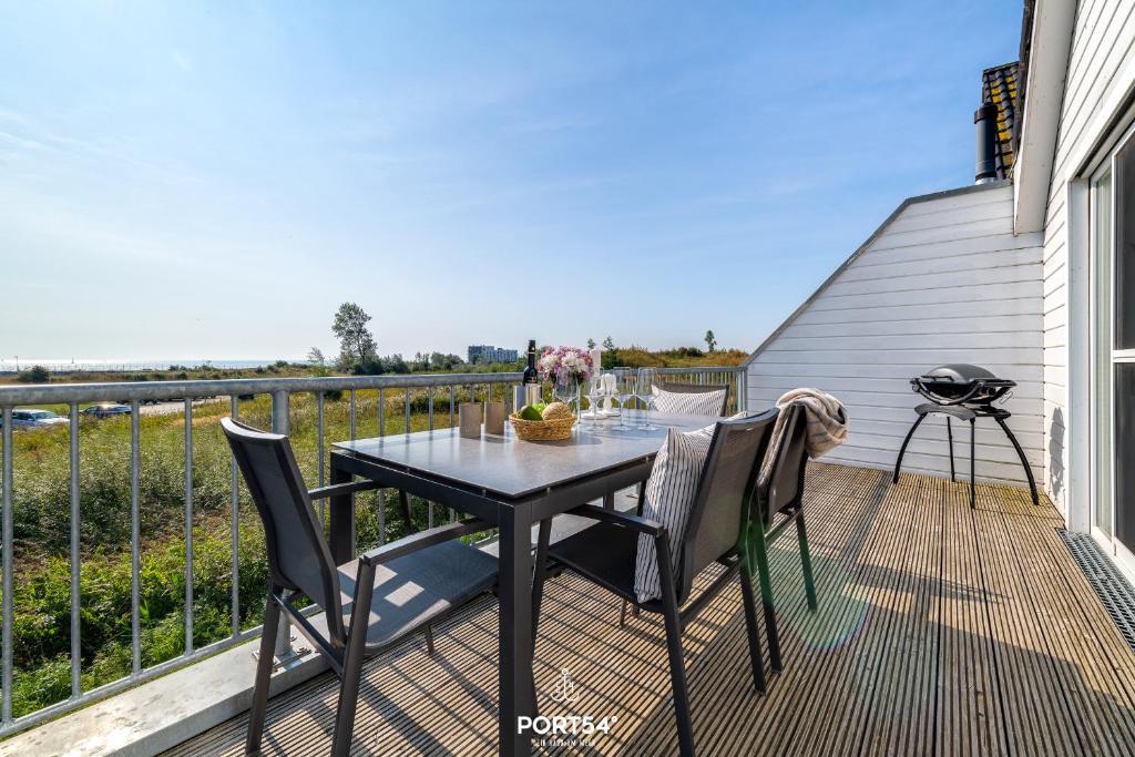 a patio with a table and chairs on a balcony at Ferienwohnung La Mer Olpenitz in Olpenitz