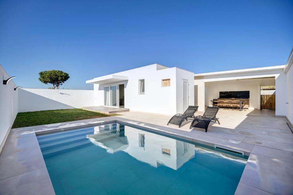 a swimming pool in the backyard of a house at Villa Kalma in Chiclana de la Frontera