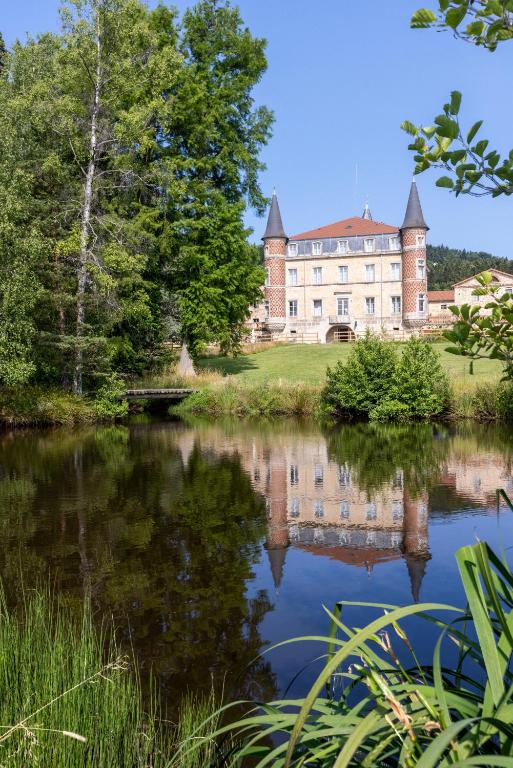 un vieux château reflété dans l'eau d'un lac dans l'établissement Domaine et Château de Valinches, à Marols
