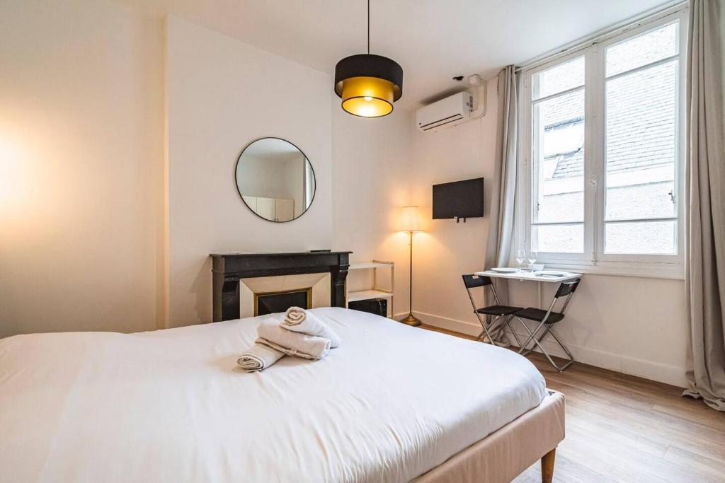 une chambre avec un lit blanc et un miroir dans l'établissement Pink, Appartement en plein cœur de Reims, à Reims