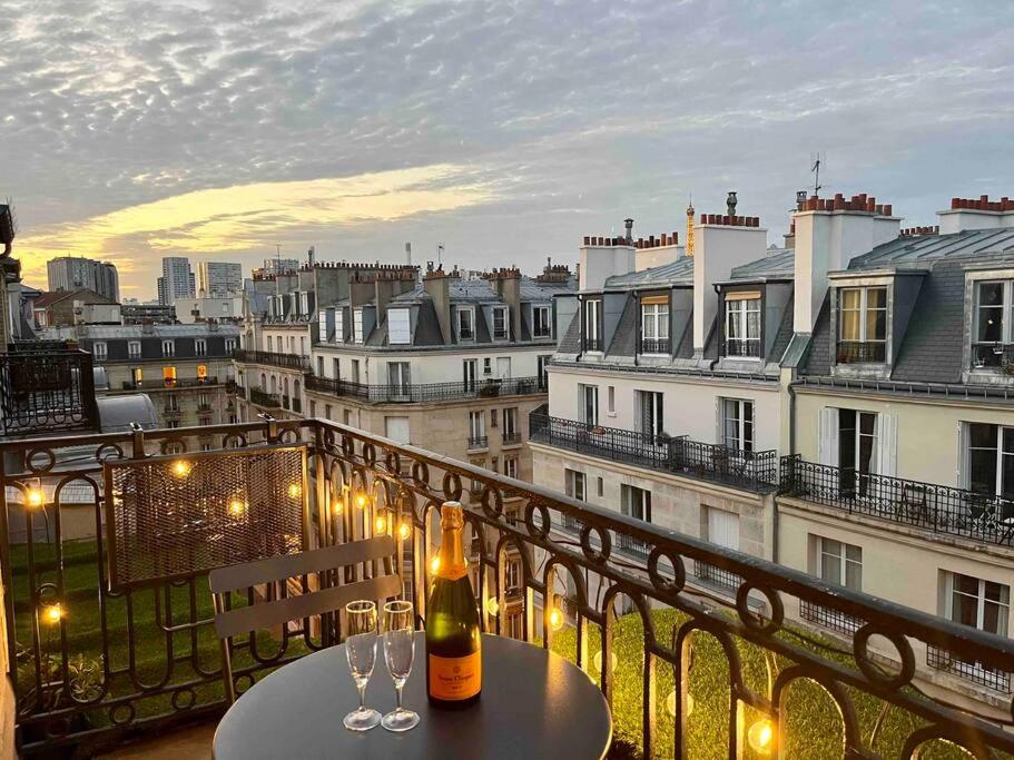 une table avec deux verres à vin sur un balcon dans l'établissement Appartement de charme, terrasse et vue Tour Eiffel, à Paris