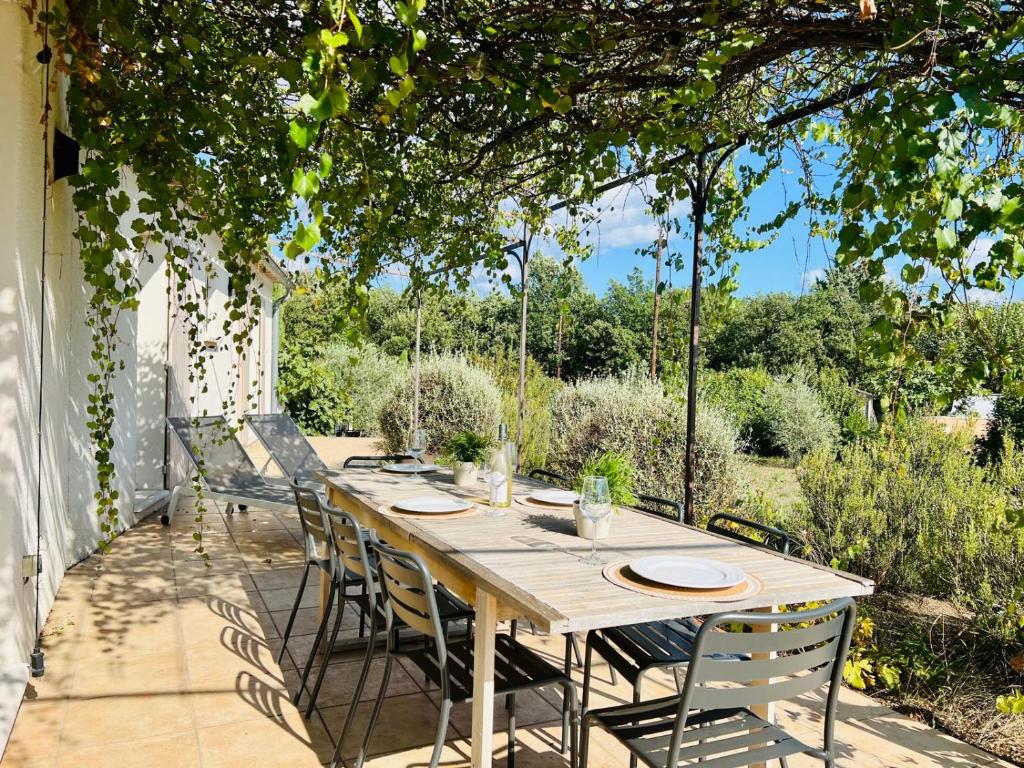 une table et des chaises en bois sur une terrasse dans l'établissement La villa Louca, à Saint-Saturnin-lès-Apt