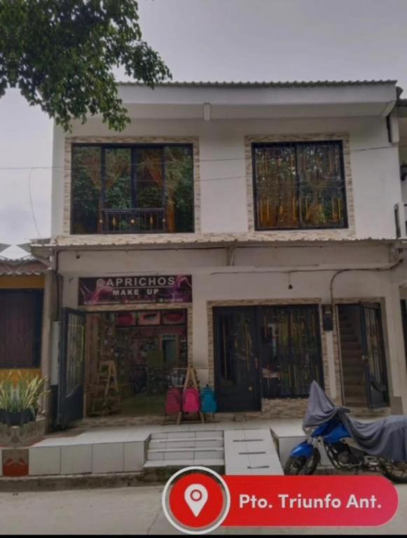 uma casa com uma motocicleta estacionada na frente dela em Apartamento Capri 1 em Puerto Triunfo