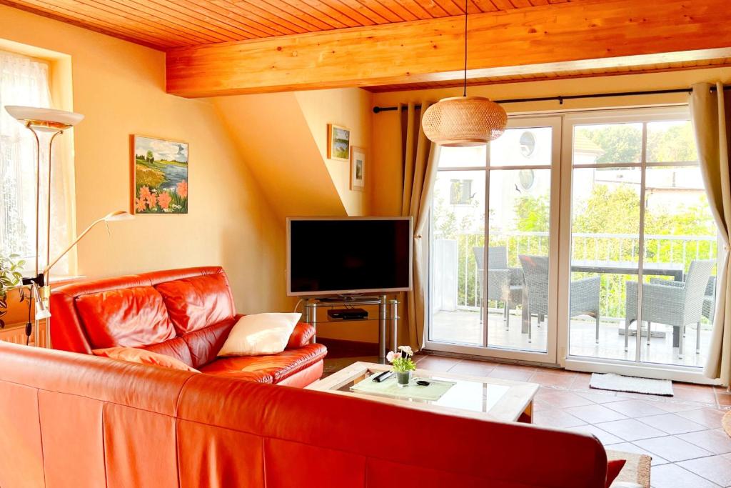 a living room with a couch and a television at Ferienwohung 3 Sandorn in Kölpinsee