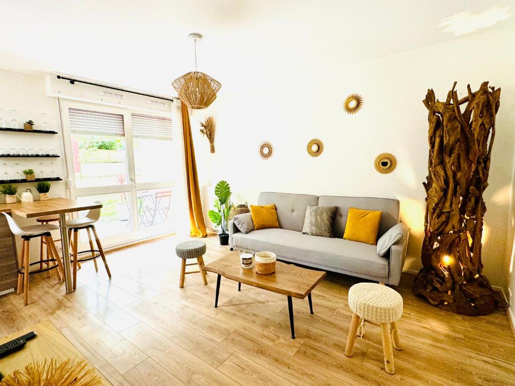 un soggiorno con un divano e un tavolo di Bel appartement proche Parc & Lac a Rennes