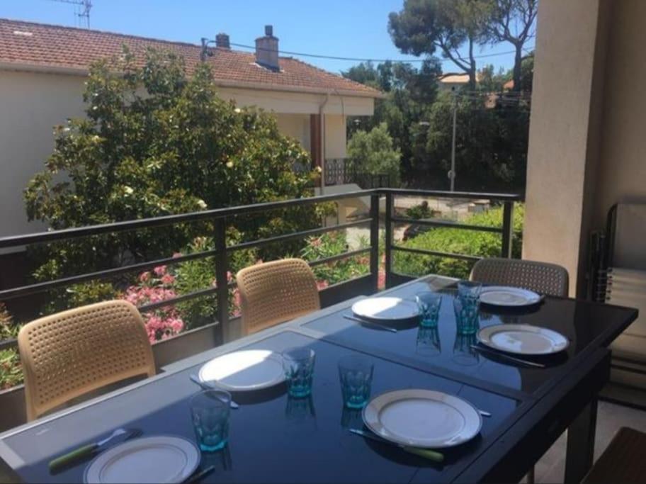une table bleue avec des assiettes et des verres sur un balcon dans l'établissement Appart 3 chambres - Mer à pied, à Saint-Aygulf