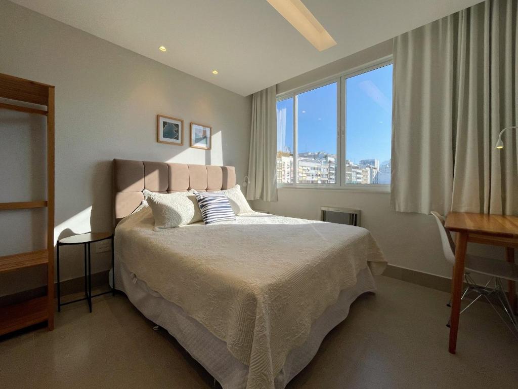 Hotel Três suítes há poucos passos da praia, a bedroom with a bed and a large window at Três suítes há poucos passos da praia in Rio de Janeiro