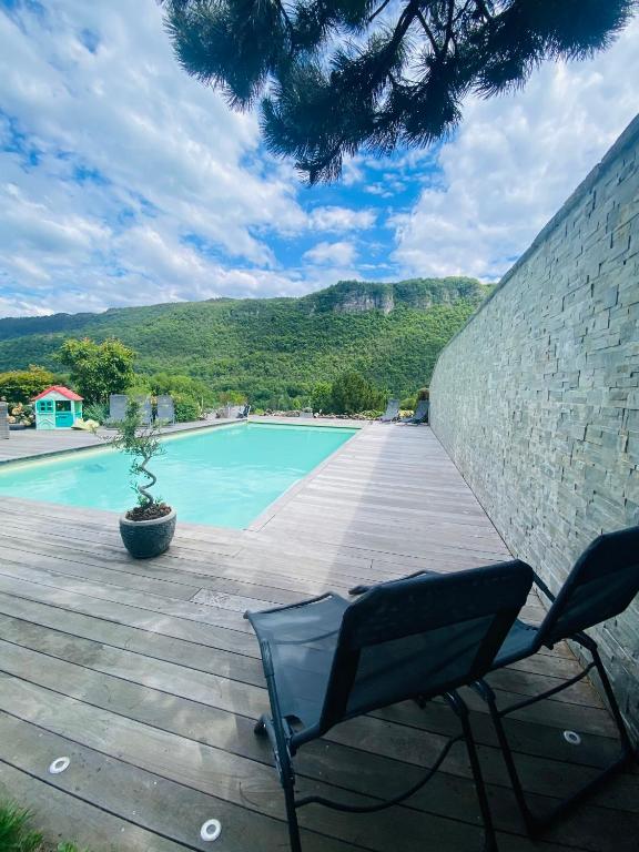 une terrasse avec une chaise et une piscine dans l'établissement Villa des 3 fontaines, à Annecy