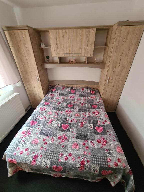 a bed in a small room with a quilt on it at Apartament 2 camere R4 in Siret