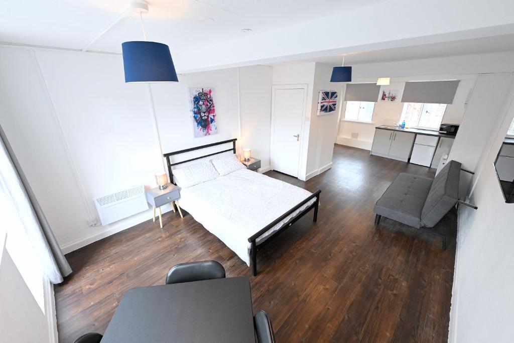 ein Schlafzimmer mit einem Bett, einer Couch und einem Stuhl in der Unterkunft Centrally located flat in Leicester Square in London