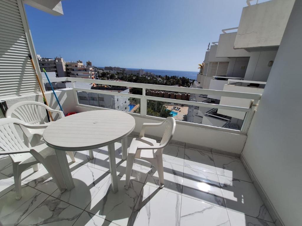 a table and chairs on a balcony with a view at Ponderosa Holiday Studio 701 in Playa de las Americas