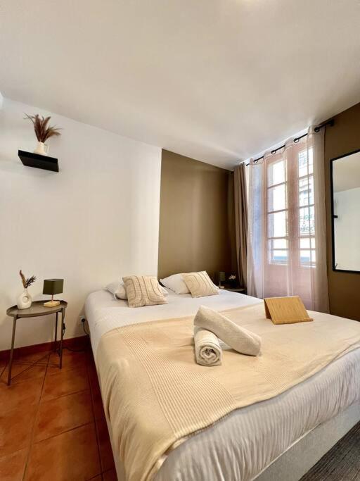 - une chambre avec 2 lits et une télévision murale dans l'établissement Les chambres de la bastide - 105, à Carcassone