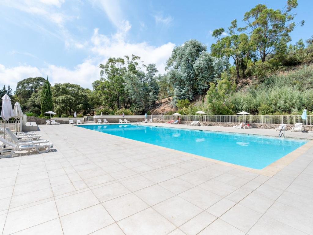 a large swimming pool with chairs and trees at Holiday Home Domaine de Maure Vieil by Interhome in La Napoule-Plage