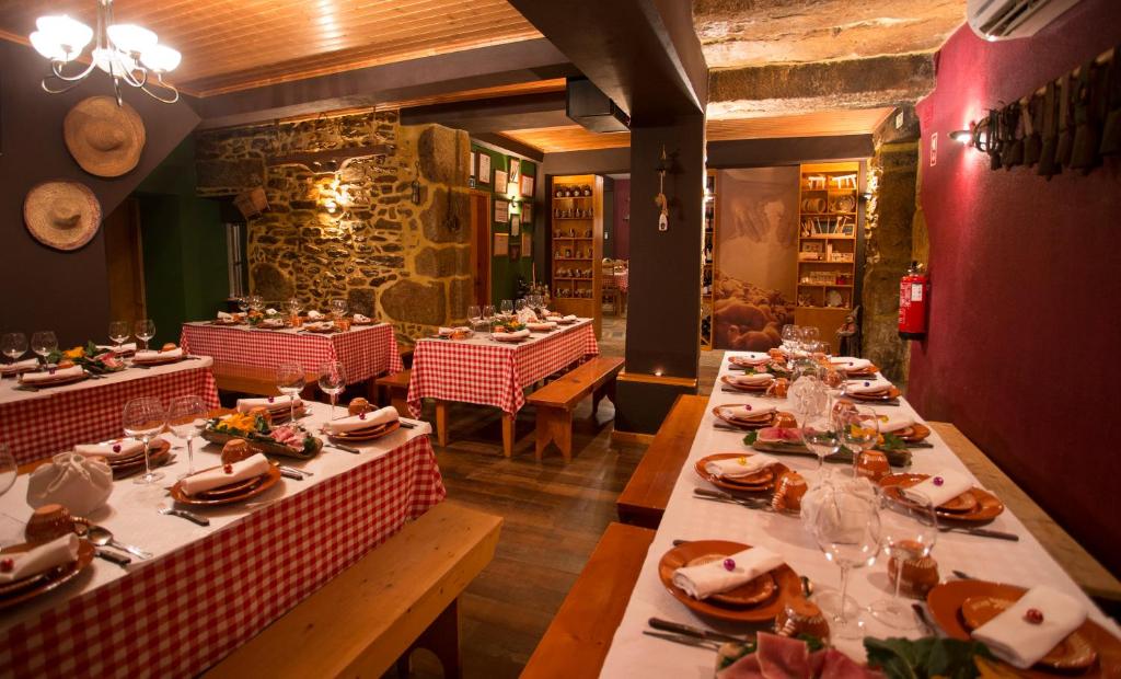 uma sala de jantar com mesas com pratos de comida em Casas do Terreiro em Seia