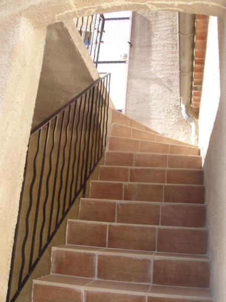 un escalier dans un bâtiment avec rampe en métal dans l'établissement T2 vue sur le château Gréoux, à Gréoux-les-Bains