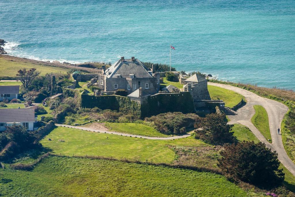 uma casa velha numa colina junto ao oceano em Star Castle Hotel em Hugh Town