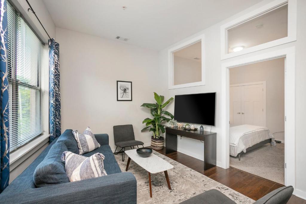 a living room with a blue couch and a tv at Music Row w Free Parking in Nashville