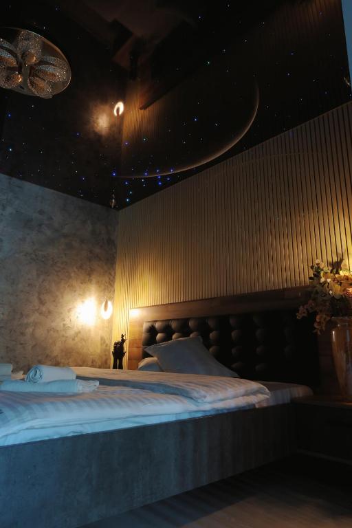 a bedroom with a large bed with a moon on the wall at Cozy Constellations in Poiana Brasov