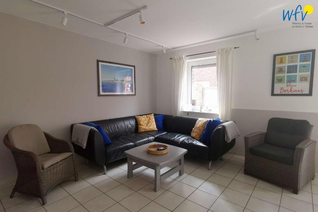a living room with a couch and two chairs and a table at Huus 24 in Borkum
