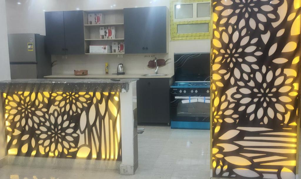 una cocina con una pared de color amarillo y negro en فيلا نون, en El Cairo