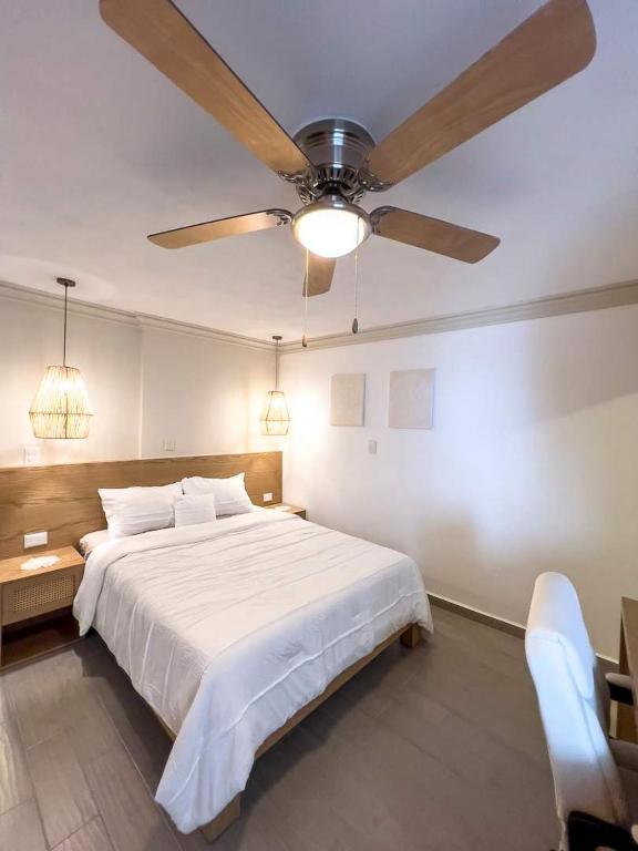 克雷塔罗Modern Apt with Workspace in Central Queretaro的一间卧室配有一张大床和吊扇