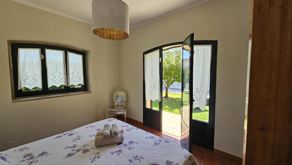 ein Schlafzimmer mit einem Bett und zwei Fenstern in der Unterkunft Casa Além Rio - quartos para 6 hóspedes em Santo Tirso in Santo Tirso