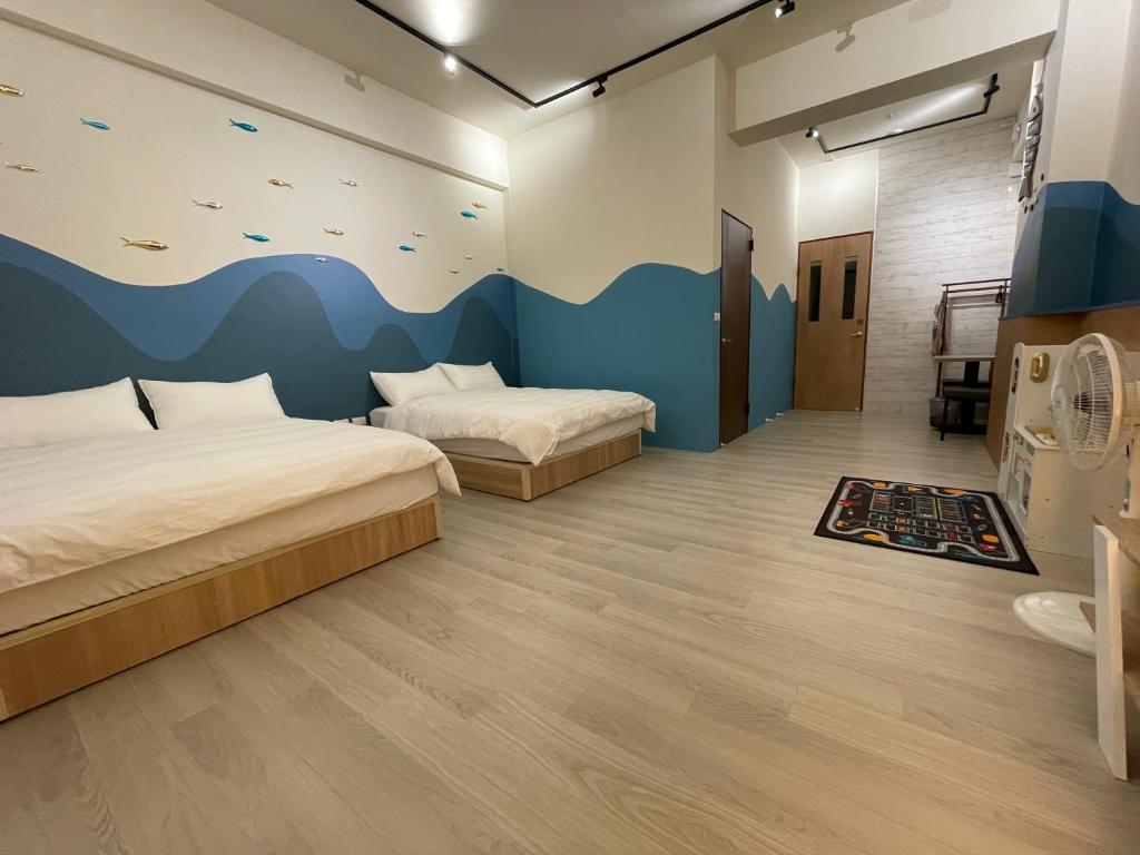 una camera con 2 letti e una parete con un murale a tema di pesce di 洄游民宿 Migration B&B a Donggang