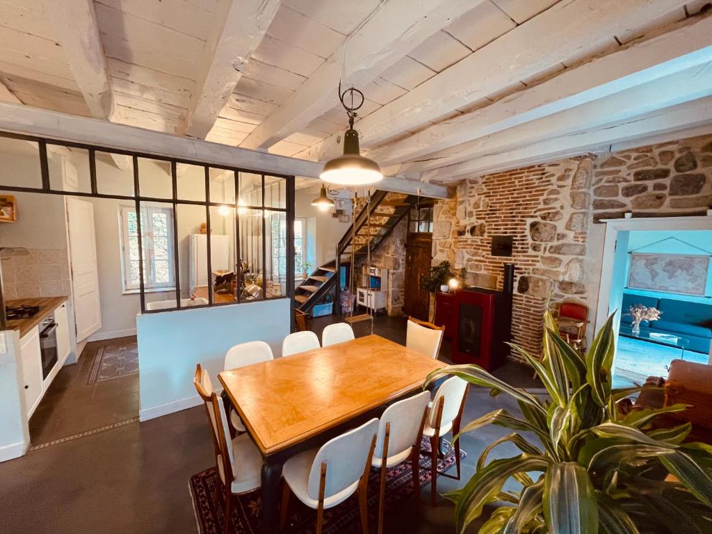 a dining room with a wooden table and chairs at Maison Albuconis, 3 chambres 150m2 avec piscine en centre ville in Aubusson