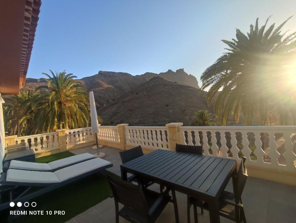 a patio with a table and chairs on a balcony at Casa Rural La Vega in Alojera
