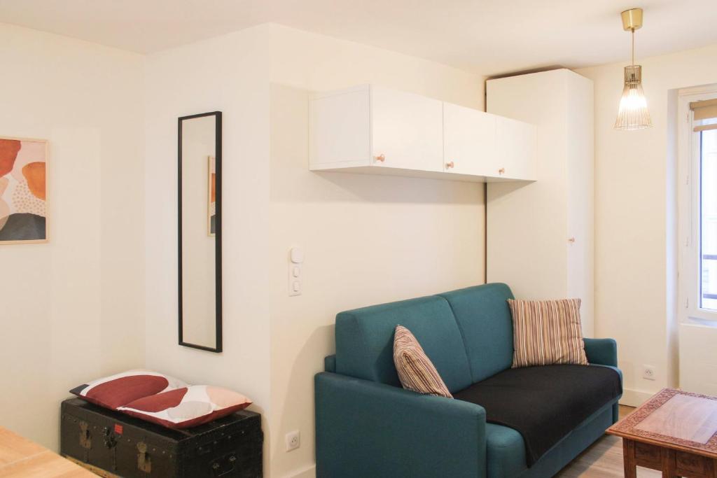 a living room with a blue couch and a table at bright studio with balcony quiet location in Paris