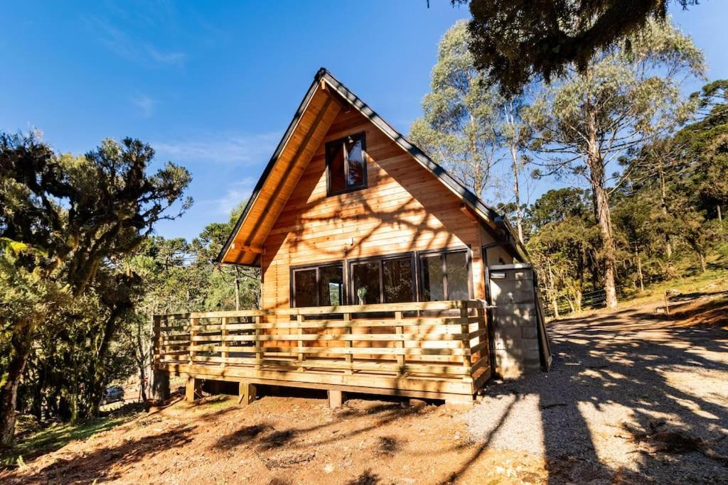 a small cabin on a dirt hill with trees at Vivenda Cambuim do Mundo Novo in Urubici