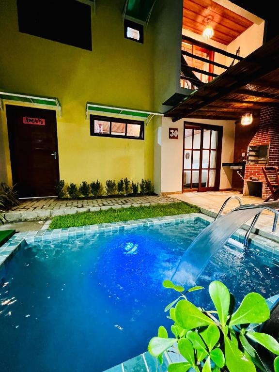 a swimming pool in the middle of a house at Duplex Villas Areias do Patacho - Praia do Patacho - Porto Pedras in Pôrto de Pedras